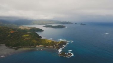 Tropik ada, plaj, kayalar ve dalgalar deniz manzarası. Catanduanes, Filipinler.