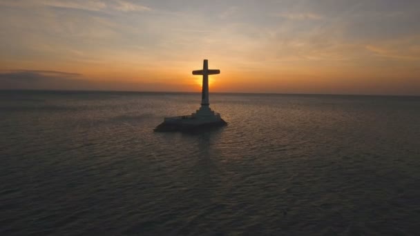 Katholieke kruis in de zee bij zonsondergang. — Stockvideo