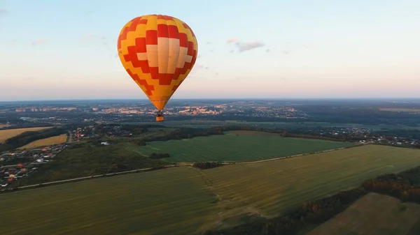 Montgolfière dans le ciel au-dessus d'un champ . — Photo