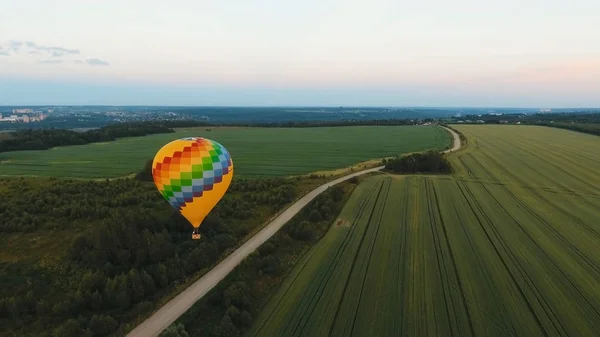 Sıcak hava balonu bir alanın üzerinde gökyüzünde. — Stok fotoğraf