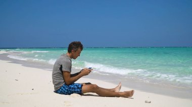 Adam sahilde tablet ile