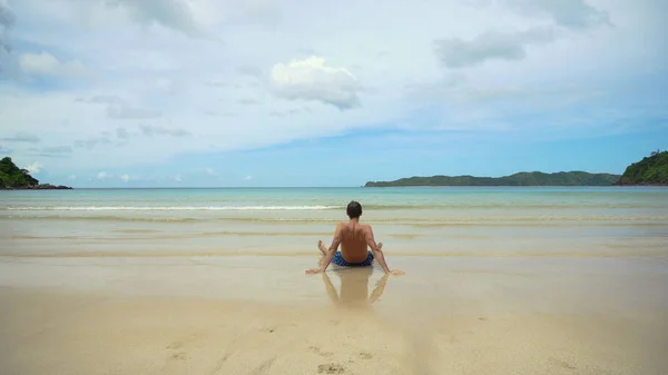 Hombre sentado en la playa. — Foto de Stock