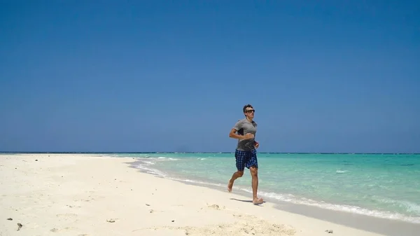 Hombre corriendo en la playa. — Foto de Stock