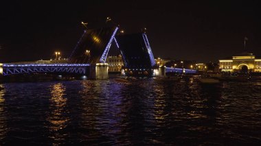 Geceleyin nehir üzerinde aydınlık bir köprü