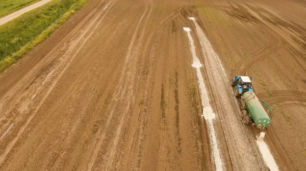 Tractor is spraying fertilizers field.