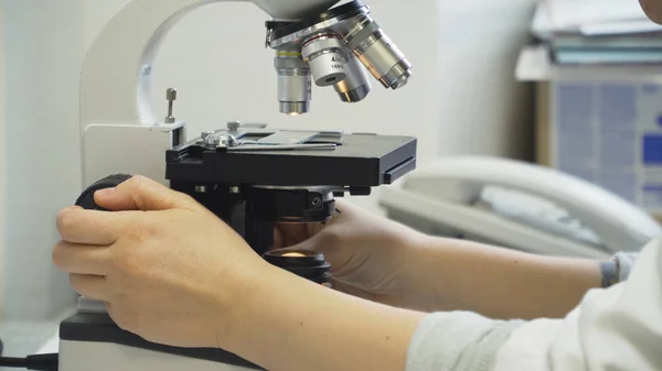 Kvinna läkare tittar i ett mikroskop. — Stockfoto