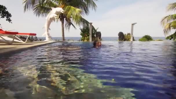 Девушка плавает в бассейне. — стоковое видео