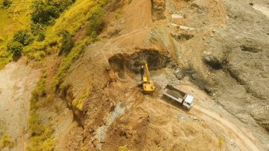 Ekskavatör ocağında kamyon yükler. Filipinler, Bohol.
