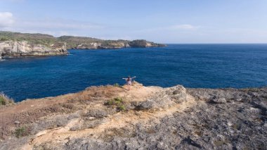 Uçurumun kenarında duran ve denize bakan bir kız. Bali, Endonezya