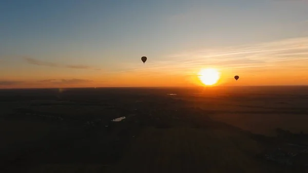 Heißluftballon am Himmel über einem Feld. — Stockfoto