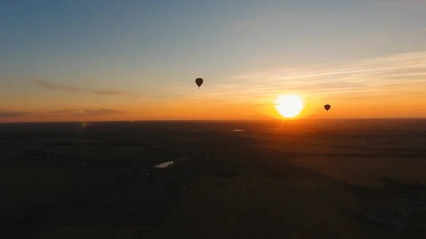 Balão de ar quente no céu sobre um campo . — Fotografia de Stock