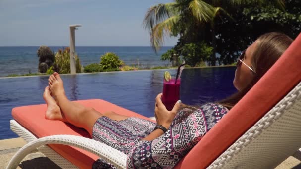 Ragazza con un bicchiere di cocktail vicino alla piscina. — Video Stock