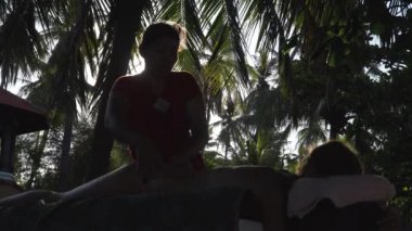 Asya 'daki bir kıza masaj yapan bir kadın. Bali, Endonezya.