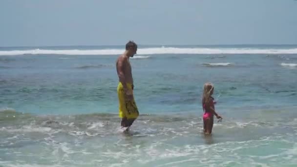 Father and daughter play on sea. — Stock Video