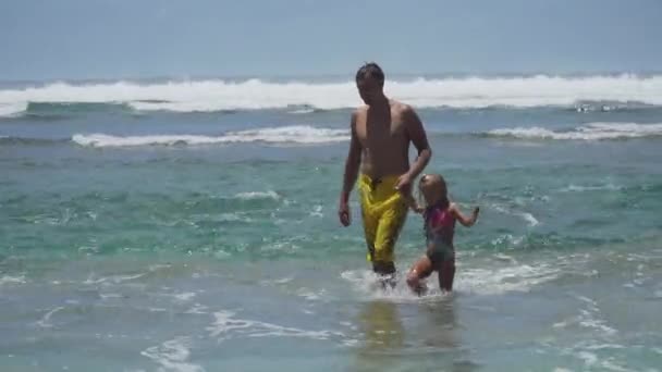 Père et fille jouent sur la mer . — Video