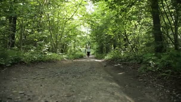Девушка бежит по дороге в поле . — стоковое видео