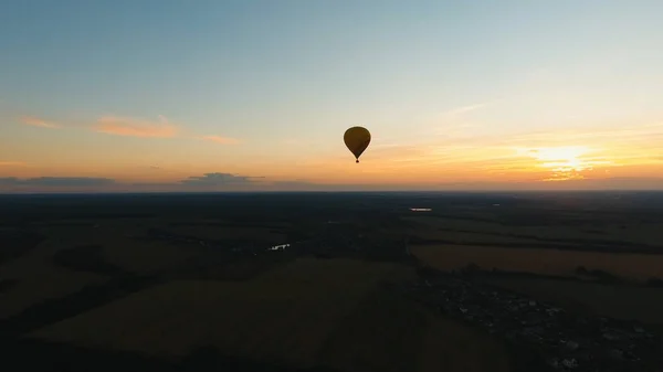 Sıcak hava balonu bir alanın üzerinde gökyüzünde. — Stok fotoğraf