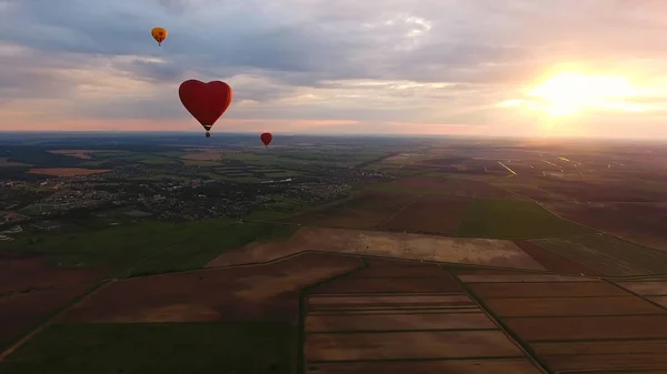 Globos de aire caliente en el cielo sobre un campo . — Foto de Stock