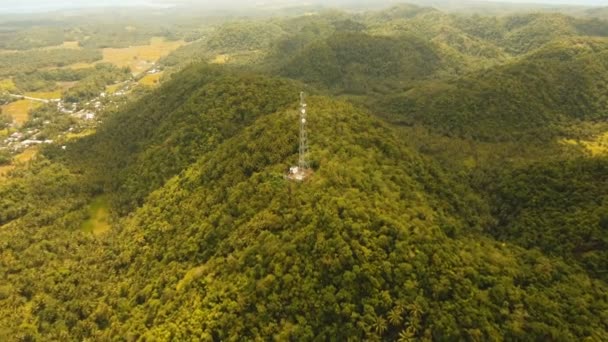 Telefon wieża sygnalizacyjna wśród zielonych lasów i gór. Widok z lotu ptaka. Siargao island, Filipiny. — Wideo stockowe