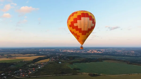 Sıcak hava balonu bir alanın üzerinde gökyüzünde. — Stok fotoğraf