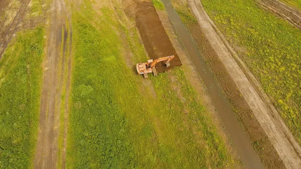 Koparka, kopanie rowów w polu. Lotnicze wideo. — Zdjęcie stockowe