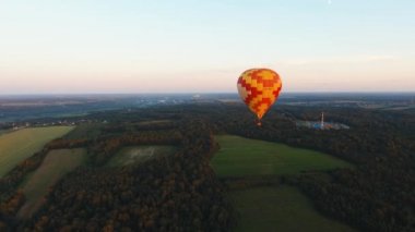Sıcak hava balonu bir alanın üzerinde gökyüzünde.