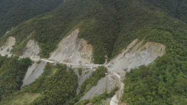 Kaya Şelalesi ve dağlık ilindeki toprak kaymaları karşı koruyucu bariyerleri inşaatı. Ağır makine bir dağ yolunda inşaat hava görünümünü. Çimento blok yol koruma