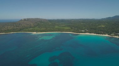 Havadan görünümü güzel tropikal Beach Saud ile turkuaz mavi lagün Pagudpud, Filipinler suda. Okyanus sahil kumlu plaj ve palmiye ağaçları ile. Asya'nın tropikal peyzaj.