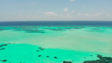 Mavi denizde mercan resifi ve mercan adası olan deniz burnu Balabac, Palawan, Filipinler.