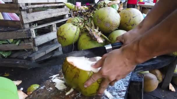 Muž krájí čerstvý kokos. — Stock video