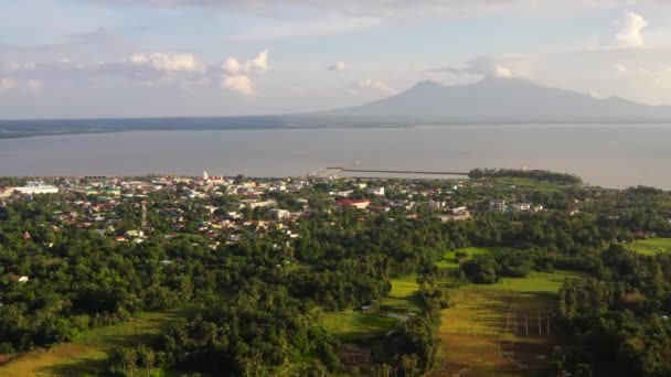 Vista de un pequeño pueblo y un volcán en la distancia. Sorsogon City, Luzón, Filipinas. Concepto de vacaciones de verano y viajes. — Vídeos de Stock