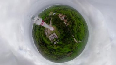 Büyük bir adada deniz feneri, manzaralı.