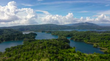 Yeşil tepeler ve dağların arasında bir göl. Pantabangan Gölü.