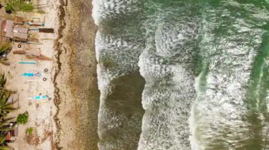 Sea waves with foam near the shore, top view.