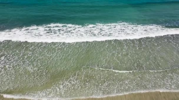 Stranden och vågorna uppifrån. Turkos vatten bakgrund från ovanifrån. Sommarlandskap från luften. Ovanifrån från drönaren. Resekoncept och idé — Stockvideo