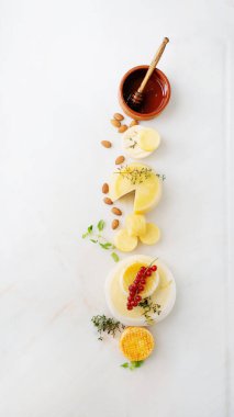 Evora Alentejo ve Azores bölgesinden geleneksel Portekiz yarı yumuşak peynirleri taze frenk üzümü, badem, bal ve kekik ile servis edilir. Üst görünüm.