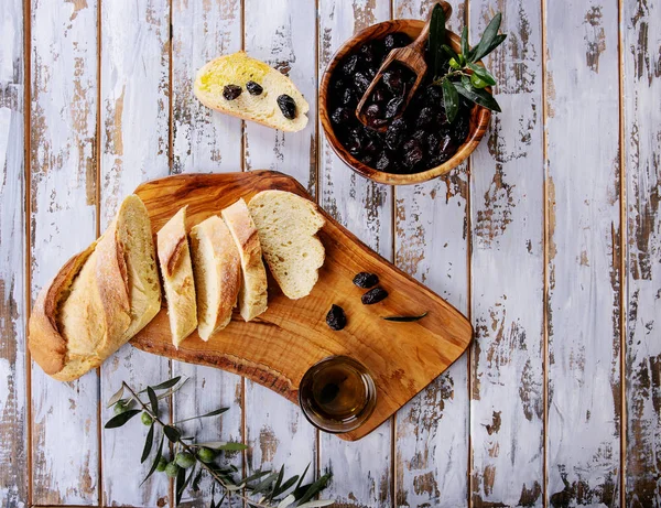 传统的希腊开胃橄榄 面包和橄榄油 在白色木质的背景下 在质朴的橄榄木木板上服务 顶部视图 — 图库照片