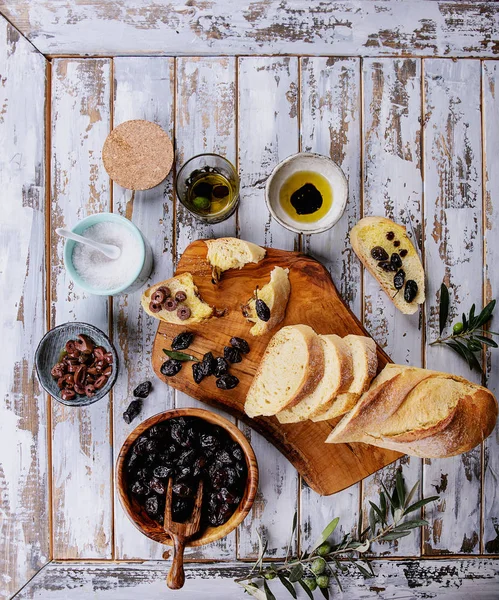 传统的希腊开胃菜橄榄与面包 橄榄油和香醋放在乡村的橄榄木板上 白色的木制背景 顶视图 — 图库照片