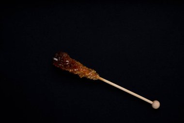 Çubuklarda şeker esmer şeker ve siyah arka planda izole şeker izleri. Kapat..