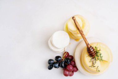 Evora Alentejo ve Azores bölgelerinden geleneksel Portekiz yarı yumuşak peynirleri taze üzüm, bal ve otlarla servis edilir. Üst Manzara. Seçici odaklanma. Boşluğu kopyala