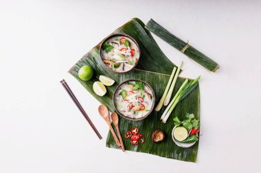 Geleneksel Tayland Tavuk Çorbası Tom Kha Gai hindistan cevizi kaselerinde taze limon, acı biber, kişniş, soğan ve şiitake mantarlarıyla servis edilir. Üst Manzara. Boşluğu Kopyala