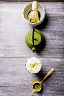 Matcha çayının ayrıştırılması: Gri ahşap arka planda çeşitli kibrit çay takımları. Üst Manzara. Boşluğu Kopyala