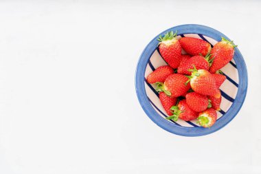 Beyaz arka planda izole edilmiş seramik kasede taze sulu çilekler. Üst Manzara. Boşluğu kopyala