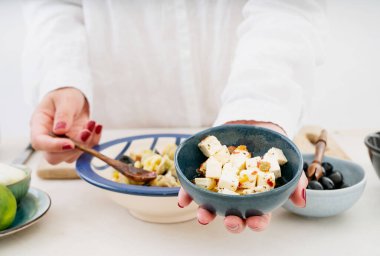 Geleneksel İtalyan makarna salatası. Orecchiette Arlecchino, kızarmış domates, soğan, siyah zeytin, limon, peynir, zeytinyağı, baharat ve otlar. Yemek pişirme süreci. Ön cephede Feta peyniri. 