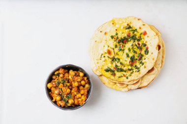 Geleneksel Hint düz ekmeği Chapati Chimichurri sosu ve bir kase Channa Masala ile servis edilir. Üst görünüm.