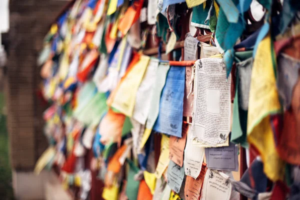 Photo of buddhist prayer flags on the wall waving on the wind in old temple Stock Image