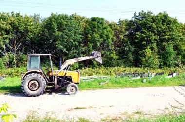 old tractor in front with bucket.