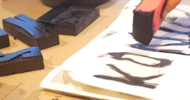Mão puxa um cartas com esponja preto pintura crianças são desenho letras pretas em Art Gallery colocar uma pintura de famílias de selos em sala de aula do jardim de infância — Vídeo de Stock