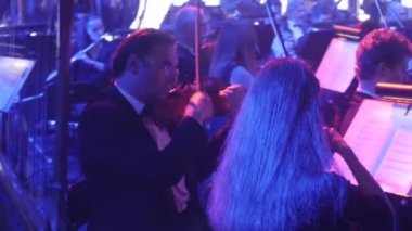 Rock Senfoni konser Ukrayna tur Kiev orkestra şefi Nikolai Lysenko müzisyenleri çello yayları müzik kitapları ile standları karanlık ışık söner üzerinde oynuyorlar