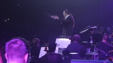 İletken müzisyenler vardır oynarken çello ile bir yay müzik kitap mavi aydınlatma standları Rock Senfoni konser Ukrayna tur Kiev Nikolai Lysenko olduğunu